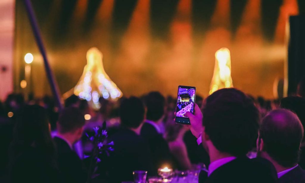 A person filming an event with his phone.