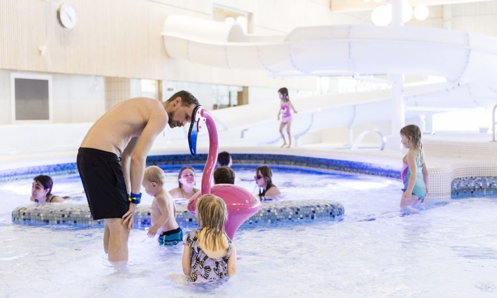 A family is playing in the pool at Tinnerbäcksbadet in Linköping.